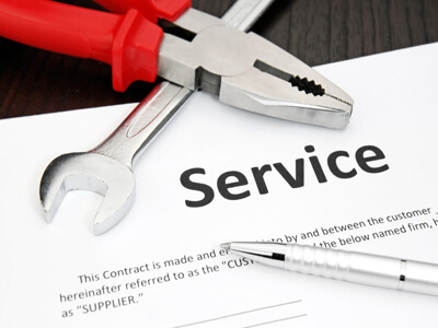service contract agreement with pen, wrench and pair of pliers